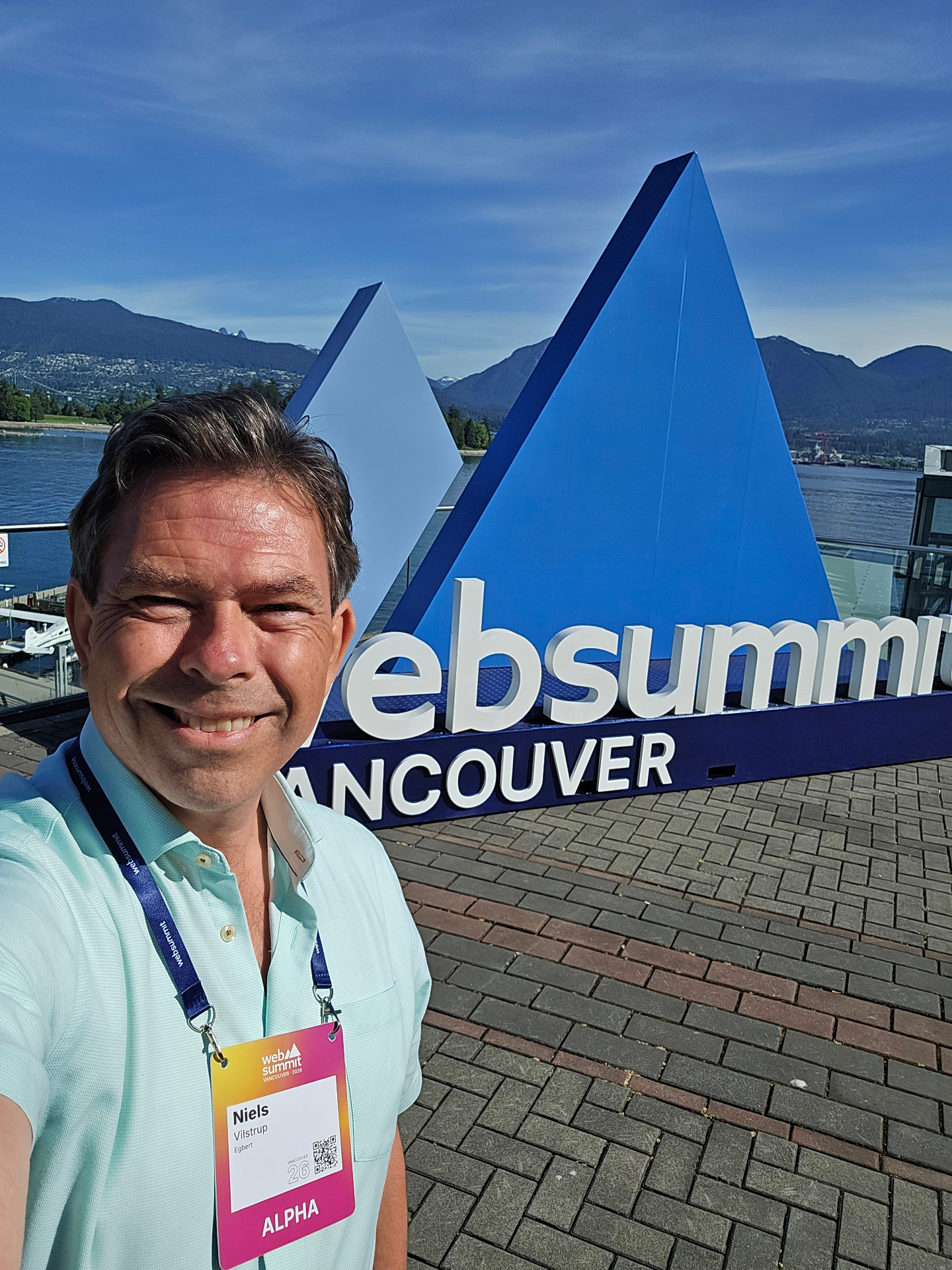 Niels Vilstrup with ALPHA badge in front of the Websummit Vancouver signage on the waterfront